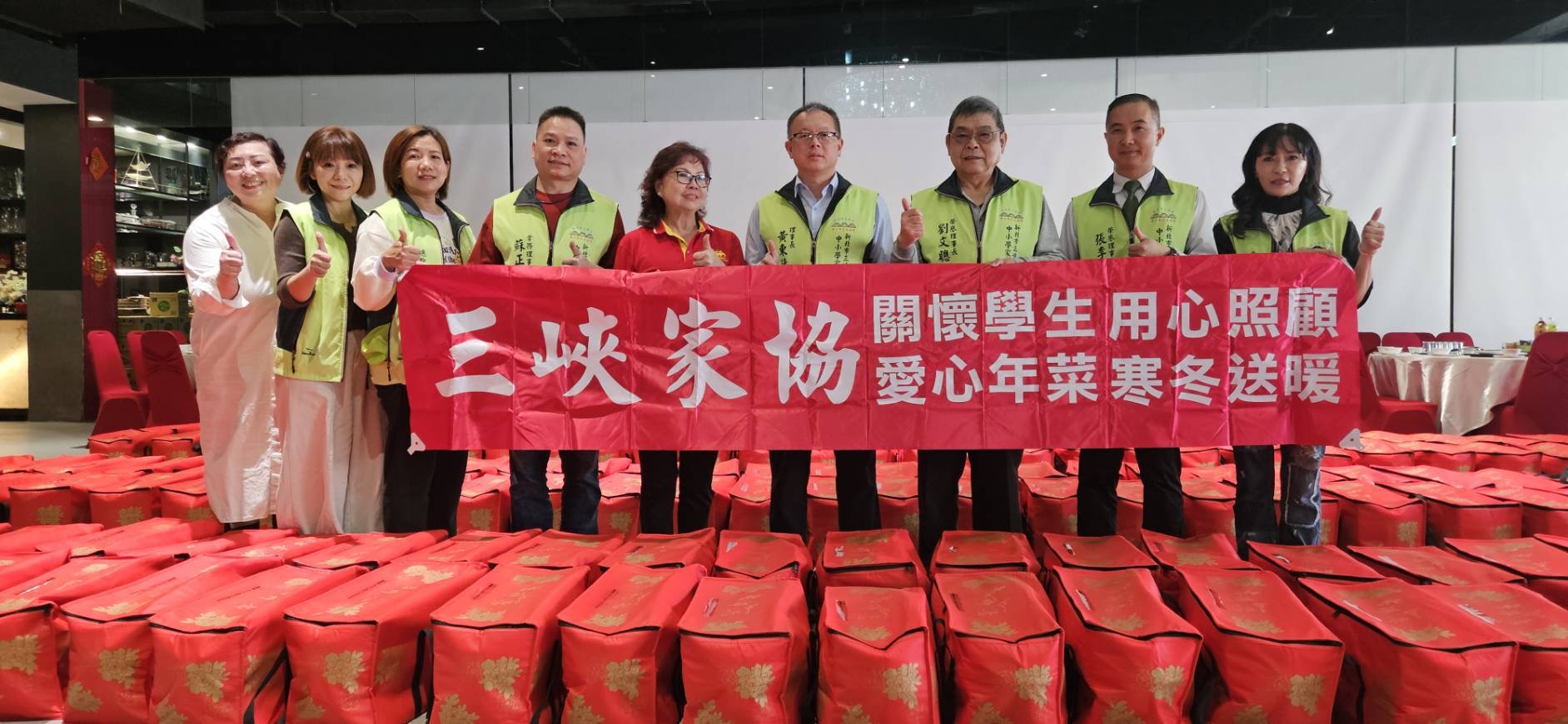 三峽家協黃理事長率領會員在三峽鼎上食府餐廳發送年菜給弱勢家庭。（圖/謝榮浤翻攝）